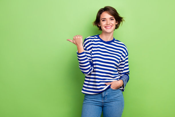 照片迷人的女孩宣传摆手口袋直接手指空的空间广告横幅海报孤立的绿色背景图片下载