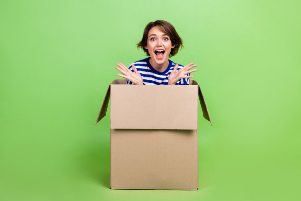 全身照片欣喜若狂的女人穿着水手衬衫牛仔裤子坐在盒子尖叫孤立的绿色背景图片下载