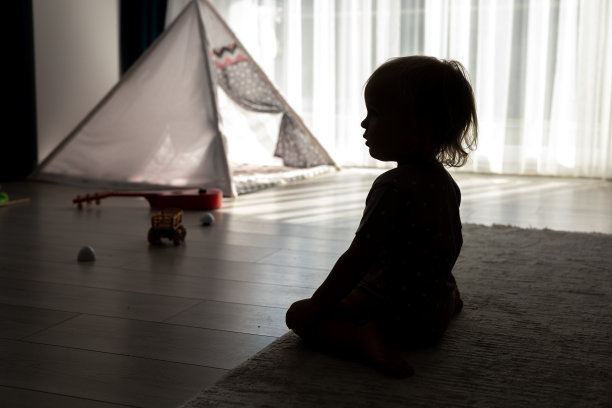 一个金发小女孩坐在家里的地板上看电视图片下载