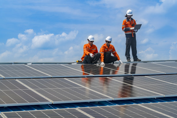 工人技术人员正在屋顶上建造太阳能电池板系统。安装太阳能光伏板系统。男技师走在屋顶结构上检查光伏太阳能组件。图片下载