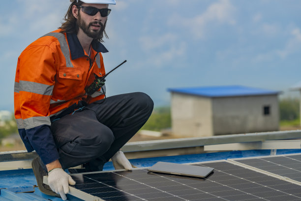 工人技术人员正在屋顶上建造太阳能电池板系统。安装太阳能光伏板系统。男技师走在屋顶结构上检查光伏太阳能组件。图片下载