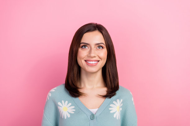 照片中迷人的年轻女孩漂白洁白的牙齿微笑抬头空空穿套头衫开衫孤立的粉红色背景图片下载