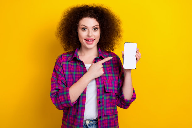 美丽有趣的年轻女子chevelure发型的照片表明手指手机界面电子商务提供孤立的黄色背景图片下载