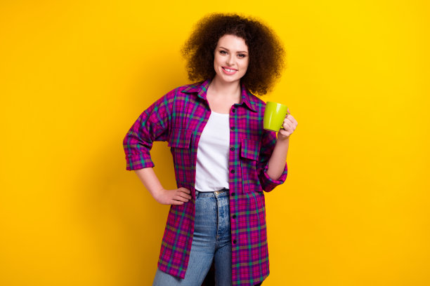 心情好的商业女士首席执行官经理的照片拿着杯新鲜的咖啡喝能量饮料穿着格子衬衫孤立的黄色背景图片下载