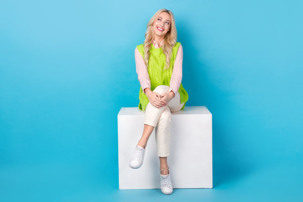 华丽的正面女士的全身照片坐在讲台上看起来空的空间孤立的蓝色背景图片下载