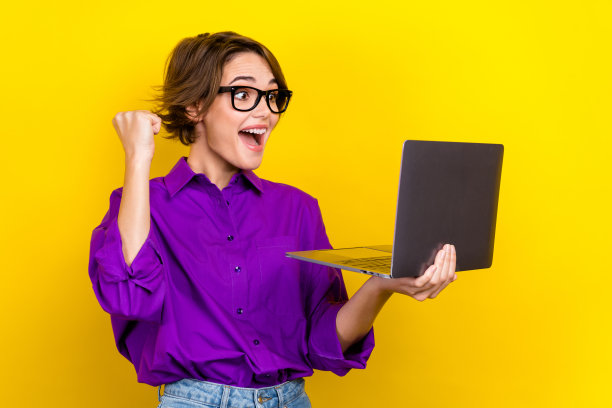 图为美国政府授予的年轻的喜出望外的商务女士的照片，她首先拿着上网本，在黄色的背景上孤立起来图片下载