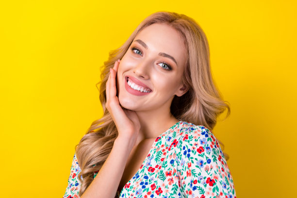 照片梦幻闪亮的女人穿着印花萨拉芬微笑手臂脸颊孤立的黄色背景图片下载