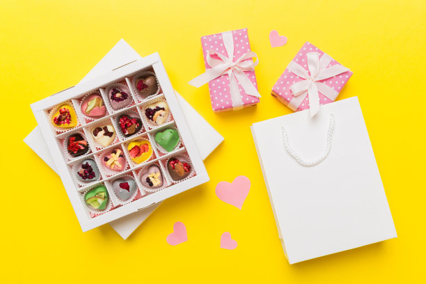 情人节作文:甜甜的糖果，带蝴蝶结和红心毡礼盒，照片模板，背景。带复制空间的俯视图图片下载