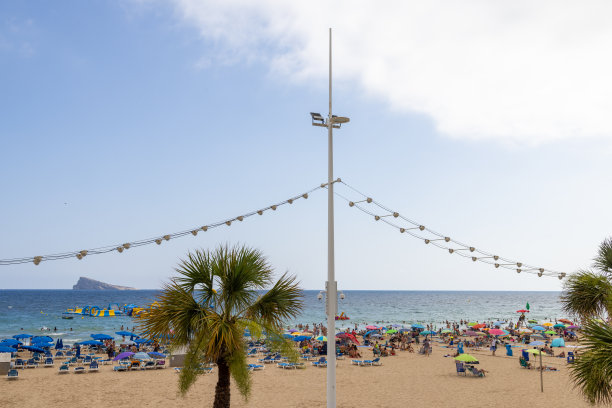 西班牙贝尼多姆著名的莱万特海滩的照片，在炎热的阳光明媚的夏天，人们在西班牙海滩上玩耍图片下载