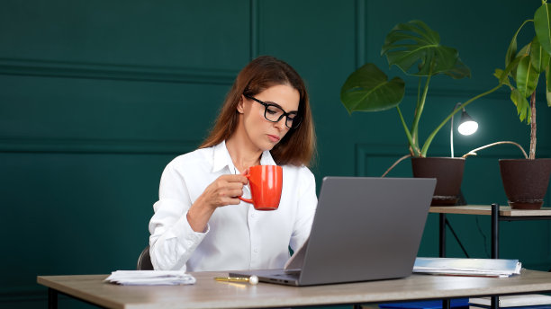 在她现代化的办公室里工作的女商人，审阅交给她的文件或发票。适合专业工作、办公效率、财务管理等主题。图片下载