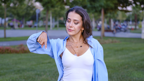 在公园里，一位年轻漂亮的女商人用食指指着屏幕的一角图片下载