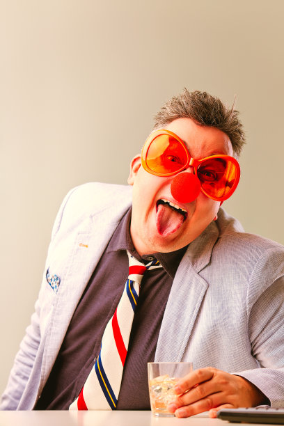 穿着小丑服装上班喝酒的商人图片下载
