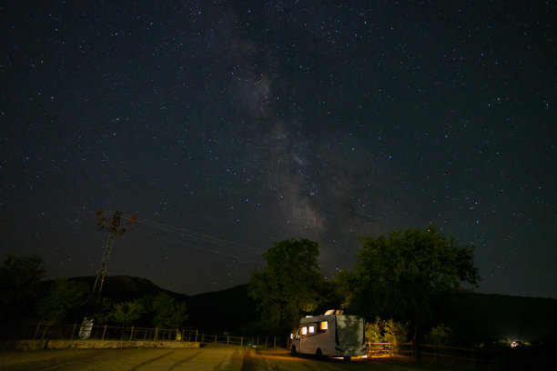 一辆房车在星空下的乡村夜景照片。图片下载