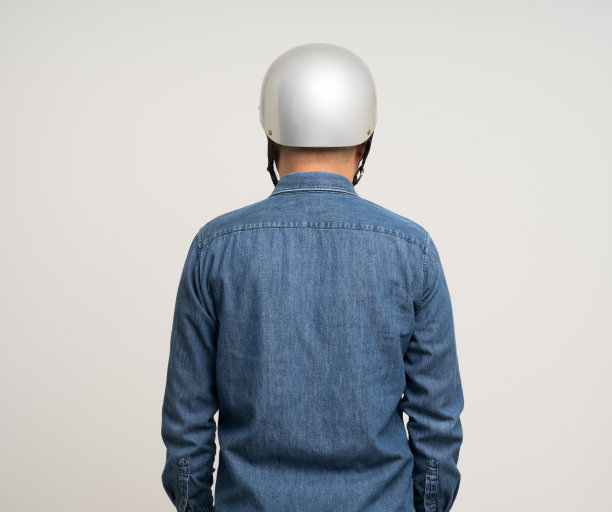 年轻骑手男子在骑摩托车前戴着安全帽。安全的旅程。图片下载