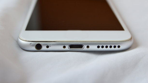 使用过的智能手机在白色亚麻背景的底部视图图片下载