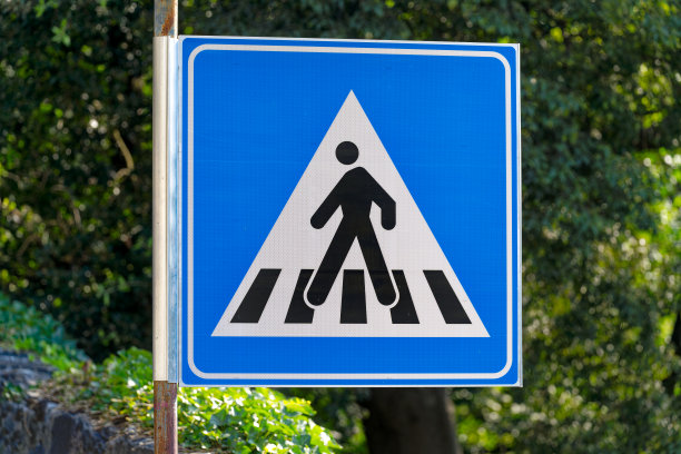 意大利小镇的街道标志特写，注意散焦背景的人行横道。图片下载