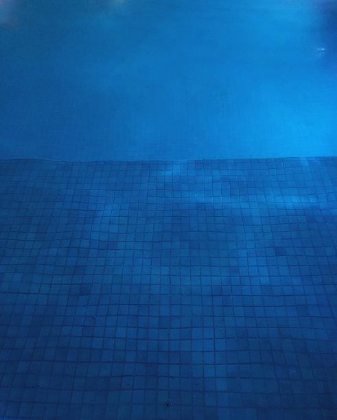 蓝色瓷砖泳池底。图片下载