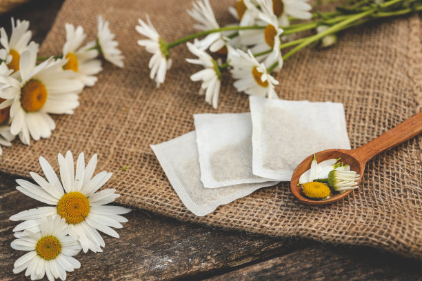 一包洋甘菊茶。装在木质背景袋里的洋甘菊茶图片下载
