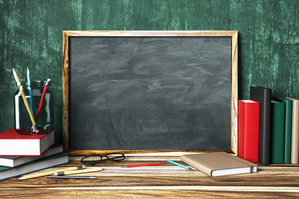 黑板模型，木框，书，铅笔和眼镜在教室设置的木桌上图片下载
