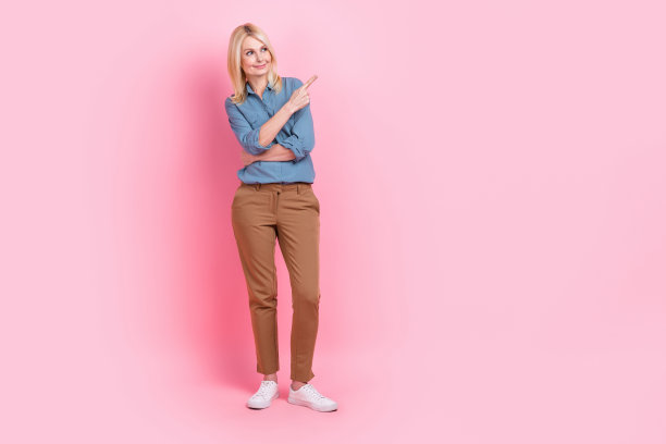 自信的广告客户的全身照片老商务女士穿办公室看起来直接手指模型主张孤立在粉红色的背景图片下载