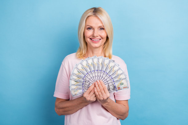 照片积极退休的人直发穿着白色t恤手拿很多钱孤立在蓝色背景图片下载