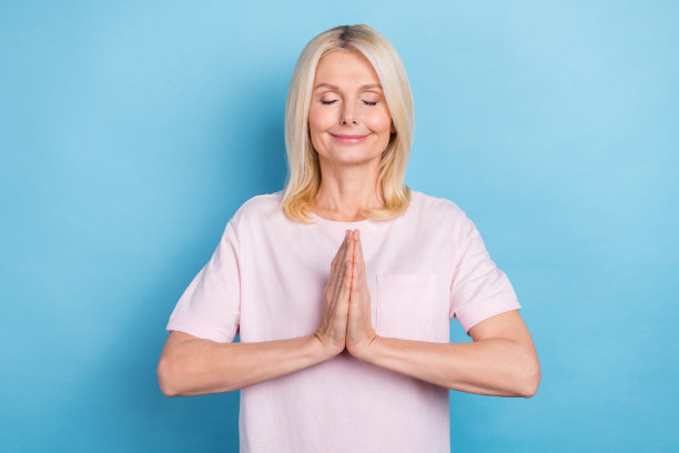 照片可爱的平静老人闭上眼睛，手臂，手掌祈祷冥想孤立的蓝色背景图片下载