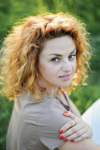 一头红卷发的快乐年轻女子在户外休息冥想。与自然合一。图片下载