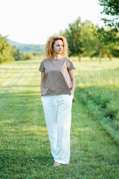 一头红卷发的快乐年轻女子在户外休息冥想。与自然合一。图片下载