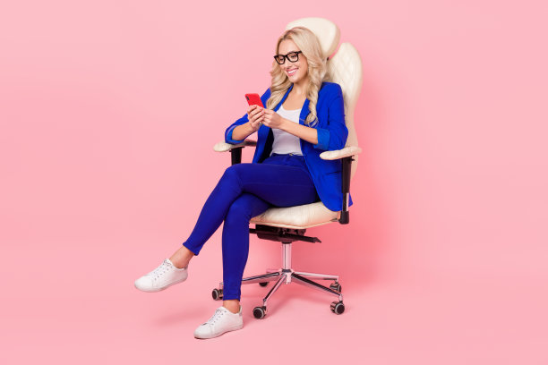 商务女士招聘人员的照片坐在办公室扶手椅拿电话发电子邮件空缺招聘孤立的粉红色背景图片下载