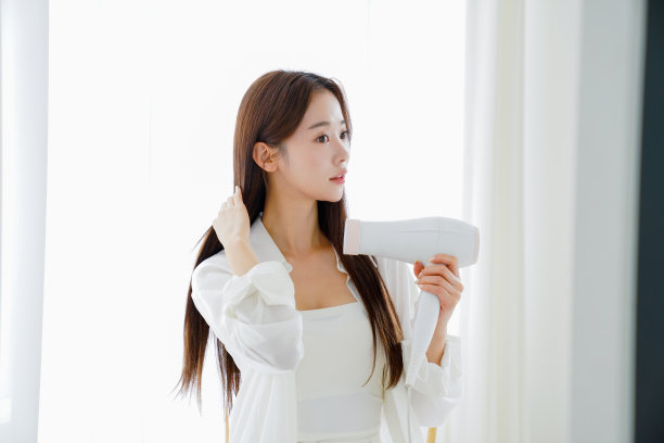 美丽的年轻女子在打理自己的头发图片下载