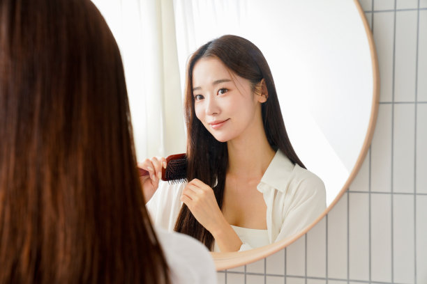 美丽的年轻女子在打理自己的头发图片下载