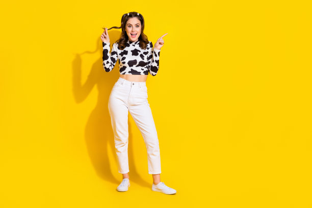漂亮印象深刻的女孩穿牛皮衬衫的全长照片显示手指空白空间孤立的黄色背景图片下载