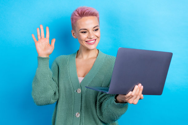 照片正面可爱的女士穿着时尚的衣服，挥手聊天的朋友和同事在蓝色的背景隔离图片下载