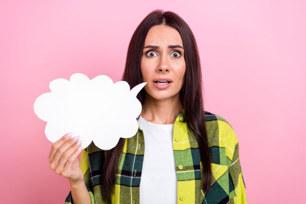 照片中震惊印象深刻的女士穿着格子夹克抱着云空空间孤立的粉红色背景图片下载