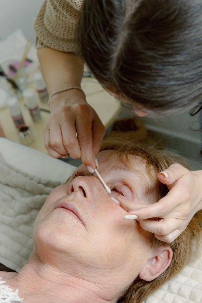 一位女美容师在给女性的睫毛贴膜。图片下载