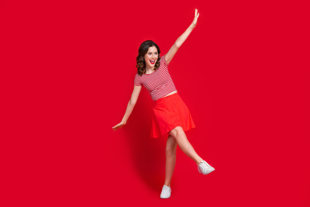 欢快的女士欢乐跳舞的青春聚会的全长照片站一条腿穿裙子顶部胶鞋孤立的红色背景图片下载