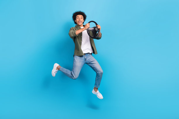 年轻司机跳人专业出租车车主握着方向盘买新车的完整尺寸照片孤立的蓝色背景图片下载