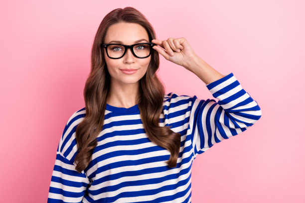 年轻成功女性的照片自信的公司员工合伙人大审计企业家触摸眼镜孤立的粉红色背景图片下载