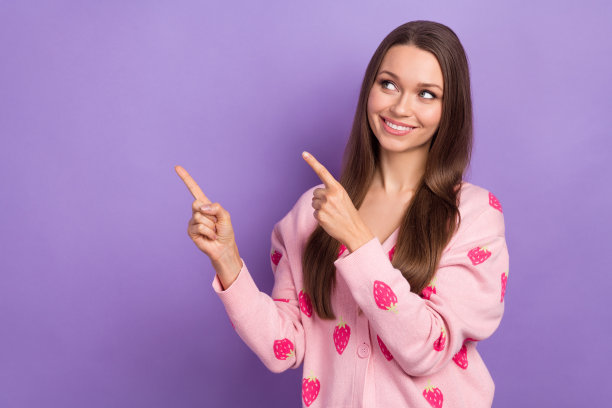 照片中可爱的梦幻女孩穿着浆果印花开衫看着两个手指看着空白的空间孤立的紫罗兰色背景图片下载