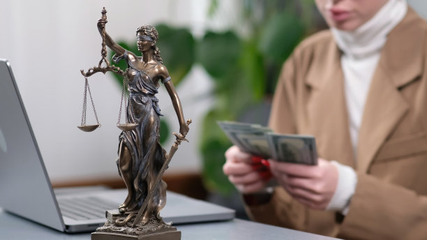 一位年轻的女律师坐在她的办公桌前数钱。金融，法律问题和法庭戏剧的主题，完美的概念，如腐败，欺诈和诉讼。图片下载