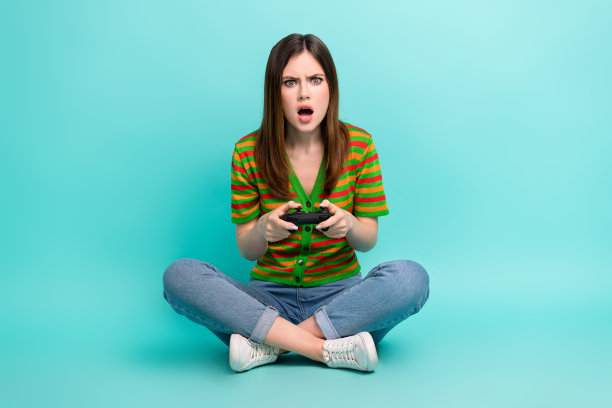 忧心忡忡的紧张女士穿着时尚的衣服玩游戏的全长照片，在青色背景上孤立的硬水平图片下载