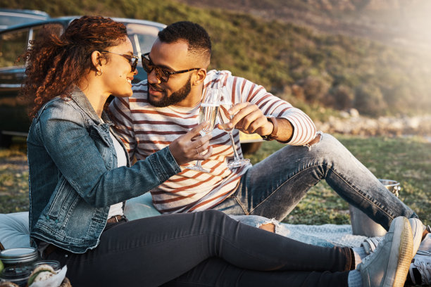 一对年轻夫妇在户外浪漫野餐时喝着香槟的照片图片下载