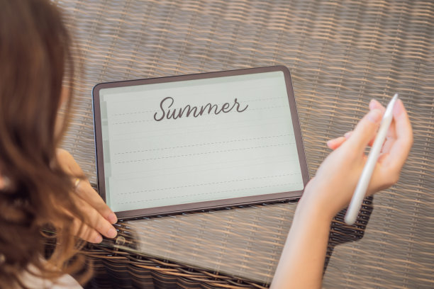 书法家年轻女子在数字平板上写短语。铭刻装饰性的装饰字母。书法、平面设计、刻字、手写、创作图片下载