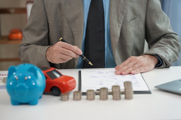 商人把硬币放进存钱罐里，把钱存到银行和住房、汽车账户里，用一堆硬币象征着房地产投资。特写照片。图片下载