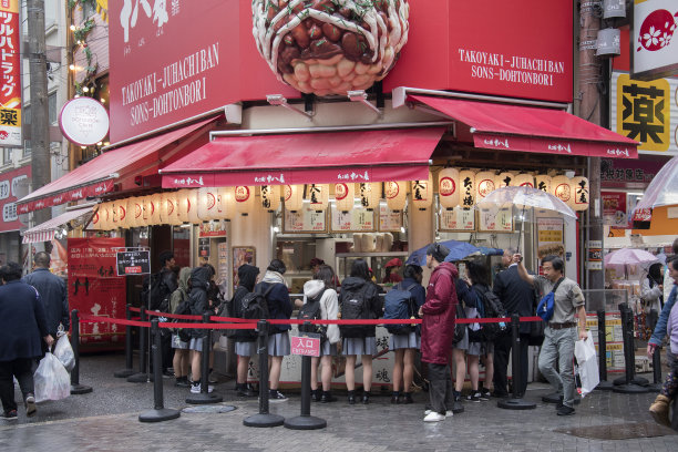 游客和当地人在大阪道顿堀排队购买著名的章鱼烧图片下载
