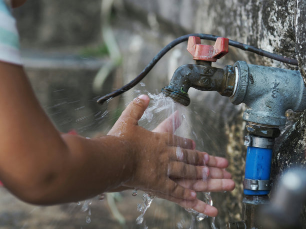 男孩在自来水下洗手的图片图片下载