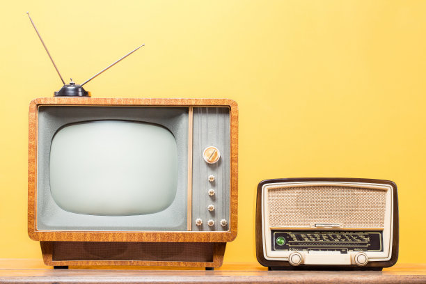 复古CTR电视屏幕和旧收音机前黄色背景。复古滤镜照片图片下载