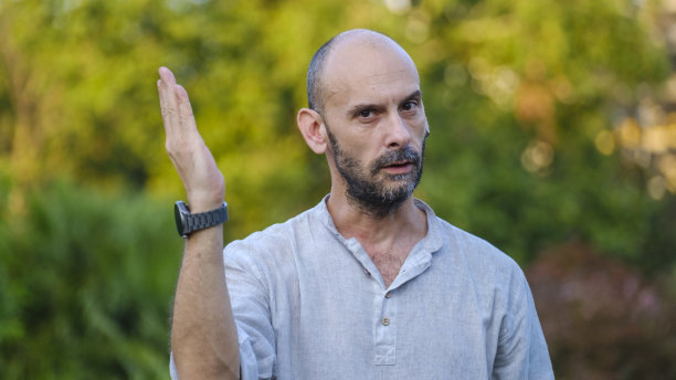 一位中年英俊的商人在公园里，看着镜头，做了一个手势表示“不”。图片下载