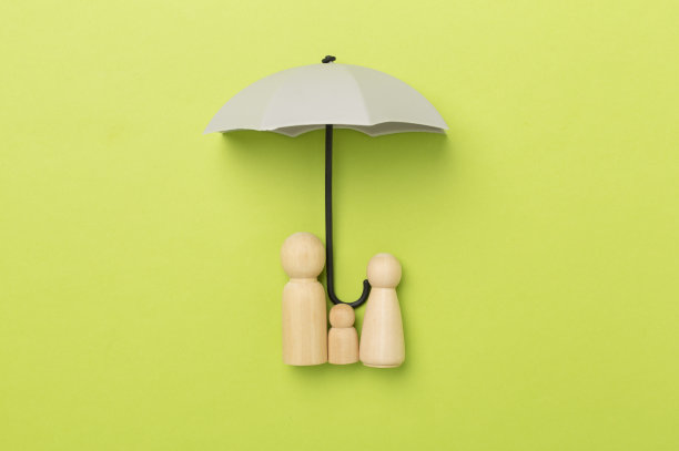 伞和木制家庭人物的彩色背景，俯视图。保险范围概念。图片下载