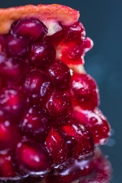 在一个反射表面上的整个和切片石榴的极端特写-库存照片图片下载